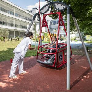 balançoire avec un enfant en fauteuil roulant