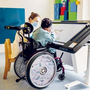 Petite fille jouant avec écran tactile accompagné par une pédiatre